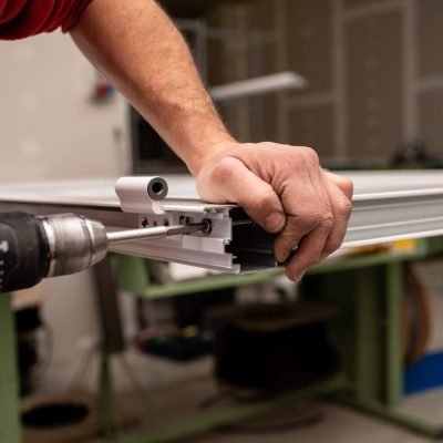 A male with a red shirt making a window with industrial tools